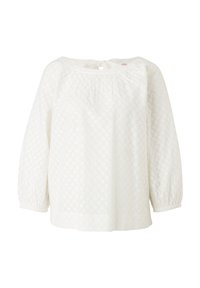 Blouse blanche avec un col froncé, de longues manches bouffantes et un tissu à œillets texturé portant des motifs floraux.