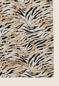 Tela de estampado de cebra con rayas negras y beige con un efecto texturizado de acuarela. Logotipo notable de la marca en oro en la esquina inferior.