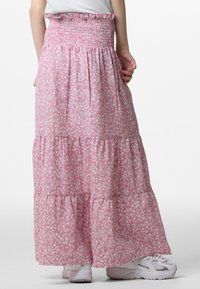 Roze bloemen maxi rok met smocktail, gelaagde delen en lichtgewicht stof. Bevat witte bloemmotieven en heeft een ontspannen pasvorm.