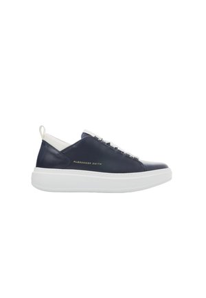 Baskets en cuir bleu marine avec une semelle en caoutchouc blanc, présentant un design épuré, des lacets décoratifs et une marque dorée sur le côté.