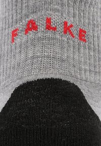 Calzini a maglia grigi e neri con risvolto superiore, caratterizzati da ricamo rosso "FALKE" e un motivo testurizzato sullo stivale per una presa e un comfort ottimali.