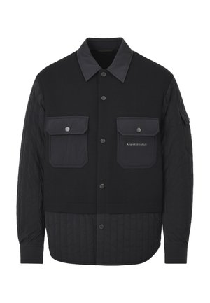 Giubbotto nero con chiusura frontale a bottoni, parte inferiore trapuntata e due tasche sul petto. Presenta un colletto piatto e tessuti a contrasto.