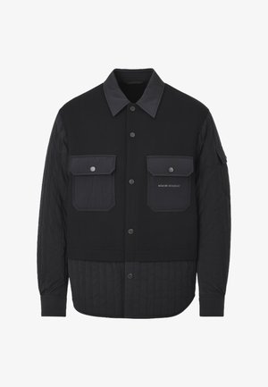 Giubbotto nero con chiusura frontale a bottoni, parte inferiore trapuntata e due tasche sul petto. Presenta un colletto piatto e tessuti a contrasto.