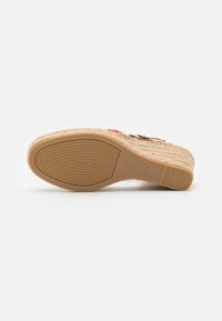 Espadrillesandale mit einer aus natürlichen Fasern gewebten Sohle, rutschfester Gummibasis und bunten dekorativen Akzenten. Verfügt über ein Plattformdesign.