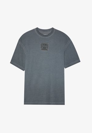 Hallitus hallistest puuvillane T-särk, millel on ümar kaelus, lühikesed varrukad ja trükitud graafika, millel on rinnal kiri "OUTER MIND VISIONS". Pehme tekstuur.