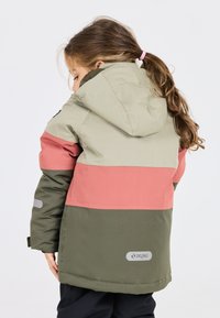 Chaqueta impermeable a bloques de color con parte inferior verde, mitad coral y parte superior verde claro. Detalles incluyen capucha, acentos reflectantes y logotipo.
