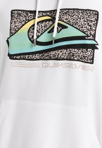 Sudadera blanca con un gran logo de Quiksilver en teal, amarillo y negro sobre un fondo texturizado, con cordones y un bolsillo frontal.