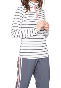Biała bluzka z długim rękawem w poziome granatowe paski, z kołnierzykiem typu mock i różowym suwakiem. Połączona z szarymi spodniami z różowymi bocznymi paskami.