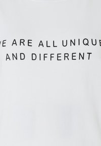 White T-shirt featuring bold black text that reads "WE ARE ALL UNIQUE AND DIFFERENT" in a straightforward sans-serif font.
