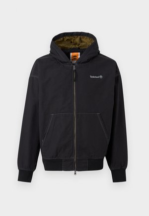 Svart hettejakke for menn med glidelås, frontlommer, olivengrønn innerforing og Timberland-logo på brystet og på merket inne i kragen.