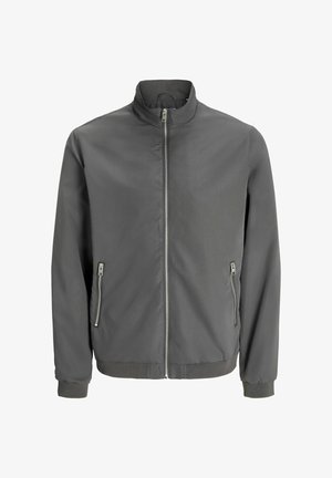 Sivá bomber bunda vyrobená z hladkej látky, s vysokým golierom, zipsovým zapínaním a dvoma bočnými vreckami na zips. Rukávy a lem sú ribbované.