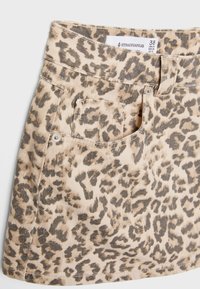 Jupe en denim imprimé léopard dans des tons beige et marron, comprenant une poche avant et un design de taille classique. L'étiquette indique la taille 38.