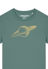 Groene katoen t-shirt met een gele afbeelding van Saturnus met ringen en verspreide sterren in een minimalistisch ontwerp.