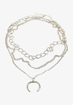 Sudraba daudzslāņu kaklarota ar dažādām ķēdēm, tostarp savienotām un delikātām ķēdēm, ar U formas piekariņu.