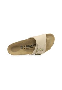 Infradito Birkenstock beige con una larga fascia, dettaglio della fibbia dorata e una soletta morbida e testurizzata, caratterizzata da un plantare sagomato.