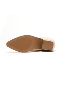 Zapato de color rosa claro con parte superior texturizada, suela de goma y punta afilada. La suela presenta un patrón acanalado horizontal para mayor tracción.
