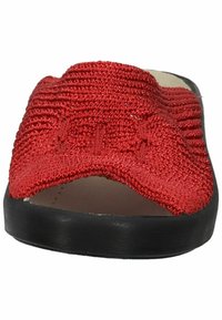 Sandale à glisser tissée rouge avec une tige texturée, un design ouvert à l'avant et une semelle noire plate. Présente une forme arrondie et des détails de couture subtils.