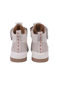 Hochschuhe aus hellbeigem Leder mit kontrastierenden roten Nähten, strukturierten Akzenten und einer braunen Gummisohle. Logo an der hinteren Ferse.