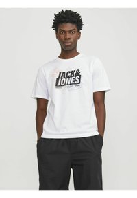 Camiseta blanca de algodón con un estampado gráfico en negro y naranja que incluye el texto "JACK & JONES", cuello redondo y mangas cortas.
