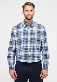 Camicia a quadri blu e verde con colletto, caratterizzata da motivi a contrasto, texture del tessuto e una tasca sul petto.