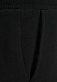 Black sweatpants made from soft cotton fabric, featuring a drawstring waist and side pockets, with a smooth texture and a classic design.