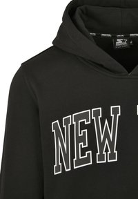 Sweat à capuche noir avec de grandes lettres blanches en contour formant le mot « NEW » sur la poitrine et une étiquette Starter Black Label à l’intérieur de la capuche.