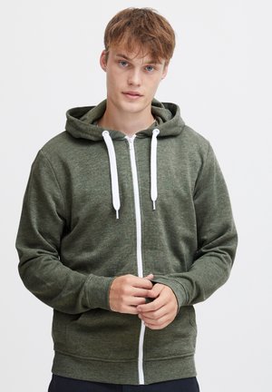 Grüne Reißverschluss-Hoodie aus einem weichen, strukturierten Stoff. Verfügt über eine Kapuze, weiße Kordeln und einen Frontzipp. Klassisches, lässiges Design.