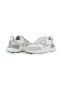 Sneaker bianchi e grigi con tomaia in pelle liscia e suede, dettagli verde menta, suola spessa e meccanismo di allacciatura visibile.