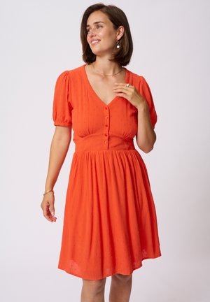 Robe orange à manches courtes avec un décolleté en V profond, en tissu texturé, devant à boutons, taille froncée, tombant jusqu'à un ourlet évasé.