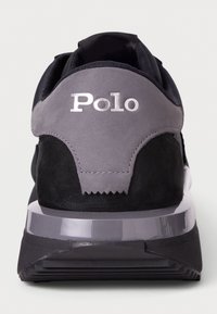 Black and grey sneaker with a mesh upper, suede accents, and a transparent sole. Features "Polo" logo in reflective silver on the heel.