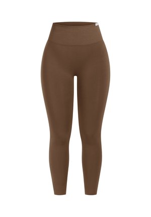 Hochtaillierte, nahtlose braune Leggings mit einem breiten gerippten Bund und einem kleinen weißen Markenetikett auf der oberen rechten Seite.