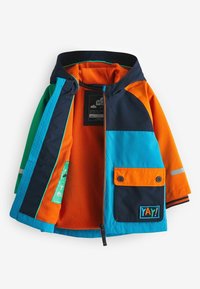 Färgglad vattentät jacka med orange, blå, marinblå och gröna paneler. Innehåller en mjuk fleecefoder, fickor och reflekterande detaljer.