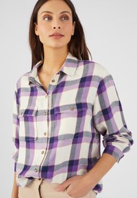Camisa a cuadros en tonos blanco, morado y gris; cuenta con cierre de botones en la parte delantera, dos bolsillos en el pecho y cuello; textura de tela suave.