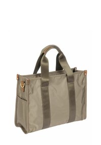 Sac fourre-tout rectangulaire beige avec des poignées beige foncé, une poche latérale et des détails en cuir sur les coins et la base de la poignée.