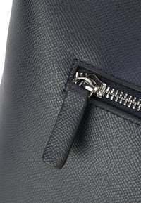 Borsa a mano in pelle texturizzata blu navy con tasca con zip dotata di una zip argentata e di un robusto tassello nero.