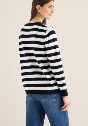 Marineblauer und weiß gestreifter Pullover aus weichem Stoff, mit rundem Ausschnitt, gerippten Bündchen und Saum, getragen mit blauen Jeans.