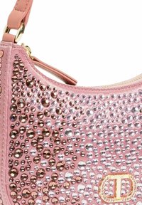 Borsa rosa con dettagli borchiati arrotondati, texture liscia, hardware color oro e chiusura con zip. Presenta un dettaglio logo sul davanti.