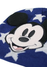 Blauwe gebreide muts met een opvallend Mickey Mouse gezicht en zwarte oren. Versierd met witte sterrenpatronen op een gestructureerde achtergrond.
