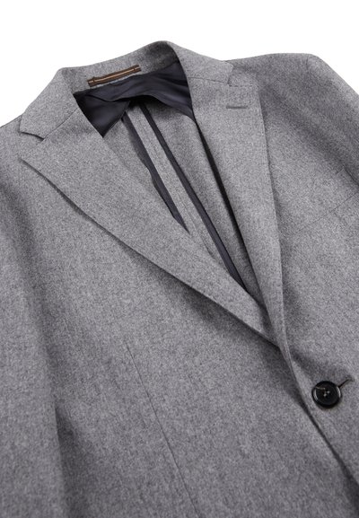Blazer grigio in lana con revers a punta, chiusura con un bottone nero singolo e fodera nera liscia. Presenta una vestibilità su misura e dettagli minimi.