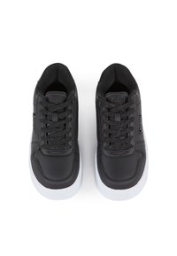 Zapatillas deportivas negras hechas de material sintético, con una superficie texturizada, cordones negros con manchas y suelas de goma blancas.