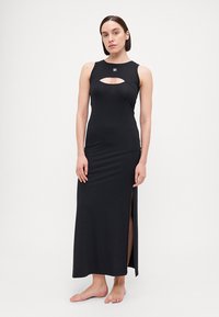 Abito maxi nero realizzato in tessuto elasticizzato, presenta un collo rotondo con un'apertura e fessure laterali, creando una silhouette aderente.