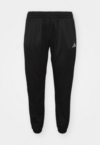 Svarta nylon joggingsbyxor med elastisk midja och ankle cuffs. Har diskreta vita ränder och en adidas-logotyp på vänster lår.