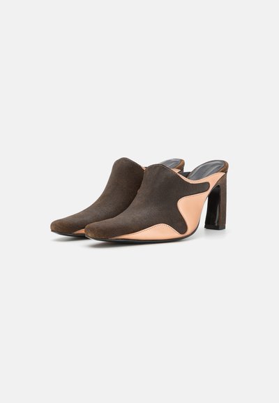 Mules en daim brun avec une accent pêche, bout pointu et un talon bloc de hauteur intermédiaire, arborant un motif en vagues sur les côtés.