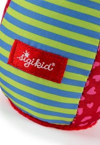 Soft toy with colorful striped fabric in blue and green, red accents, and a pink section with heart patterns. Features a branded label.