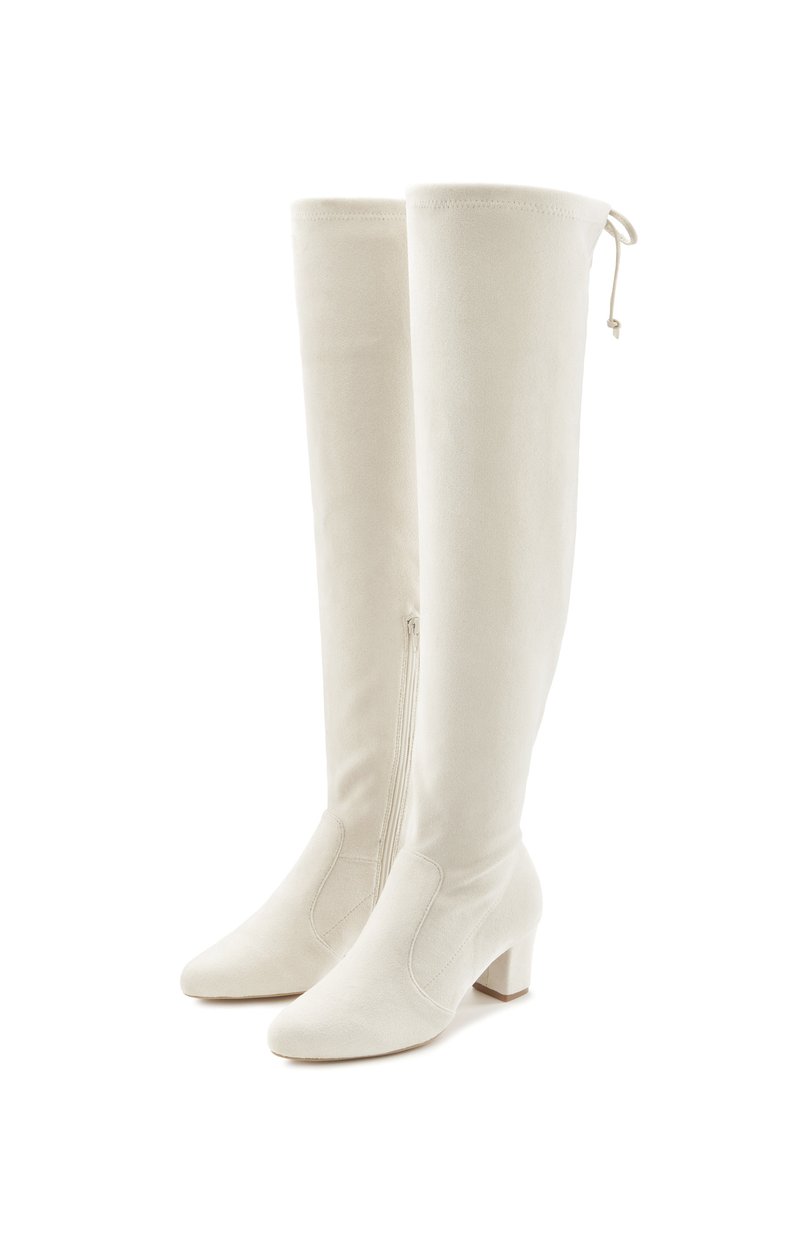 Knee-high valge sametnahast saapad, millel on sile tekstuur, terav nina ja plokknukk. Omab külgset tõmblukku ja ülemises osas nöörimist.