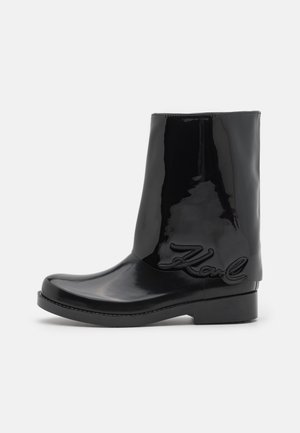 Black glossy rain boot with a rounded toe, a mid-calf design, and a textured "Karl" logo embossed on the side. Flat sole for stability.