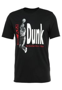 Svart bomullströja med en grafisk tryck av en basketspelare som hoppar för att dunka en boll, med texten "SLAM Dunk" och "Air Jordan från Nike".