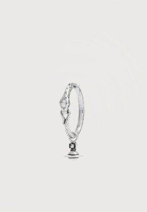 Anillo plateado con forma de serpiente, con textura de escamas y un pequeño colgante que parece una corona o una campana.