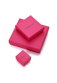Drei pinkfarbene Geschenkboxen in verschiedenen Größen, die übereinander gestapelt sind. Jede Box hat eine glatte Oberfläche und trägt den Markennamen "YOKOAMii" in Schwarz gedruckt.