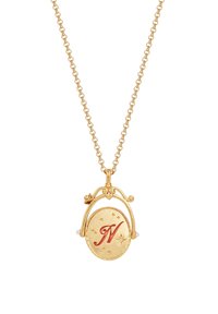 Collana d'oro con un pendente circolare che presenta una "N" rossa, circondata da stelle e accentuata con piccole perline bianche.